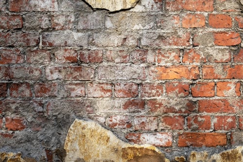 Preview: Fragment of an old red brick wall with traces of plaster.