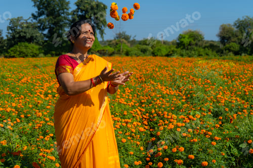 Preview: Indian woman in marigold field and enjoying nature.