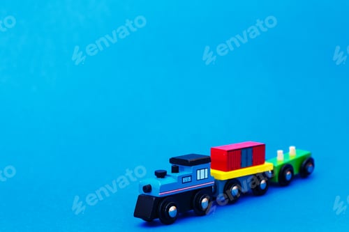 Preview: Colourful wooden toy train on blue background with copy space