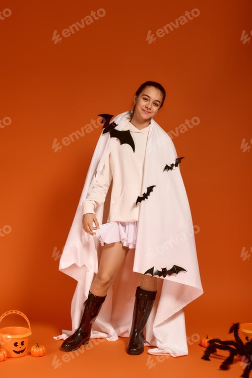 Preview: Cute girl celebrating Halloween with spooky decorations on an orange backdrop