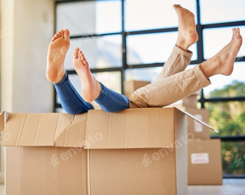 Preview: Shot of an unidentifiable young couple lying in a box together with their feet sticking out
