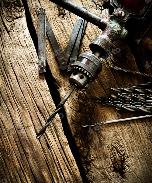Preview: Old drill, ruler and drills on wooden background.