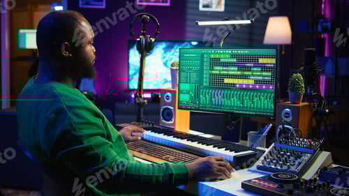 Preview: Man Composing Music with Keyboard in Studio