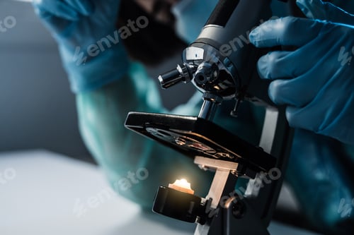 Preview: Medical doctor doing coronavirus research working with microscope inside hospital lab