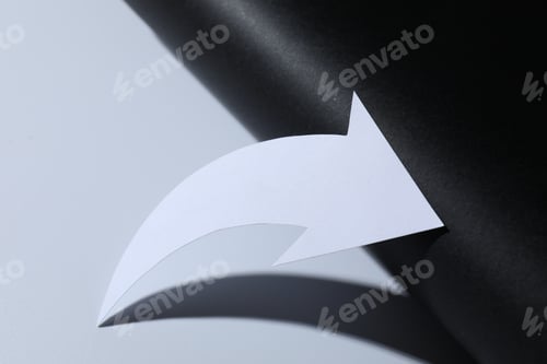 Preview: One white paper arrow on color background, closeup