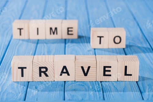 Visualização: vista de perto de blocos de madeira dispostos no tempo de viajar, frase em superfície de madeira azul