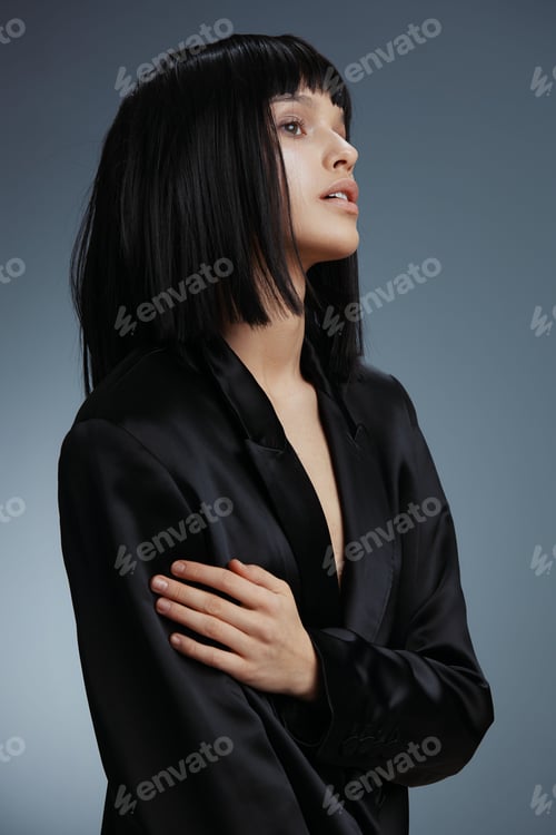 Preview: Woman, black suit, closed eyes, hands on chest a woman in a black suit stands with her hands on her