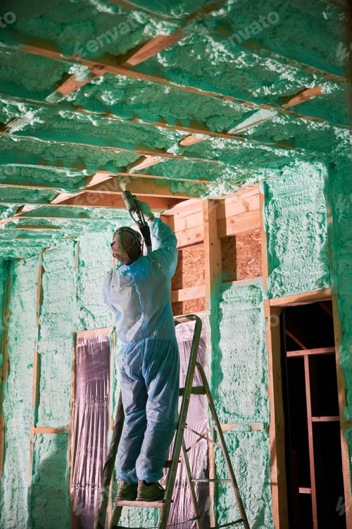 Preview: Worker spraying polyurethane foam for insulating wooden frame house.