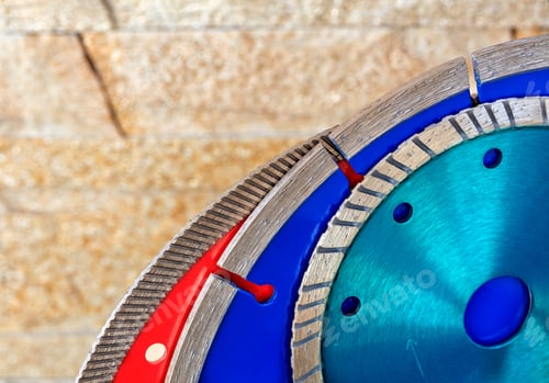 Preview: High angle closeup of disks for granite and stone against sandstone wall.