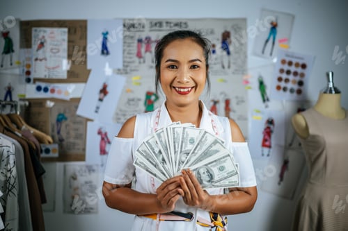 Preview: Young fashion designer posing with dollars in hand with proud
