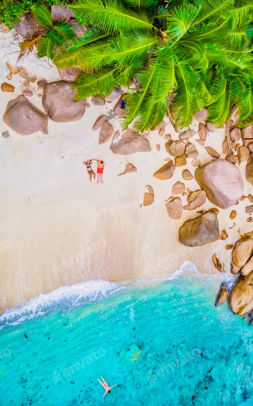 Preview: Drone view from above at Anse Lazio beach Praslin Island Seychelles, couple men and woman on beach