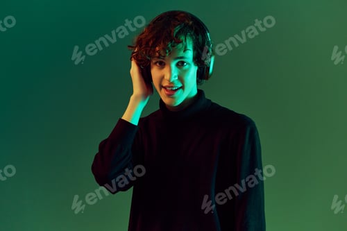 Preview: Teenage male with headphones listening to music, dancing and singing with his eyes closed, DJ