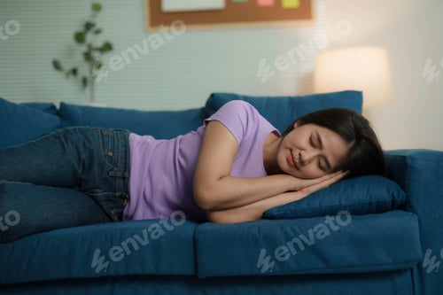 Preview: Young Asian Woman Sleeping Peacefully on Comfortable Sofa at Home