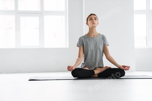 Preview: Attractive young woman practicing meditation