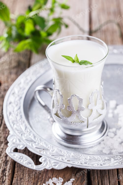 Preview: Glass of buttermilk and a bunch of mint on the tray.Milk product.