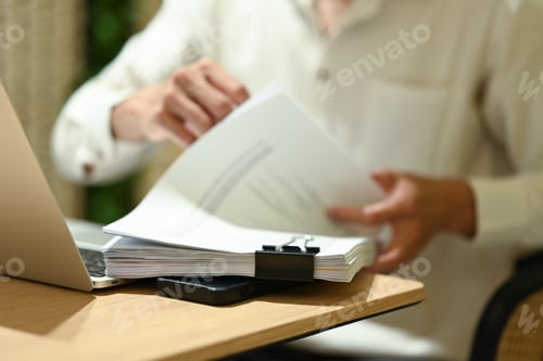Preview: Unrecognizable businessman working with documents on wooden office desk