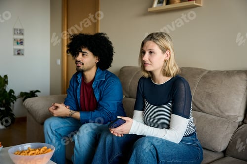 Preview: Couple relaxing on sofa watching tv at home