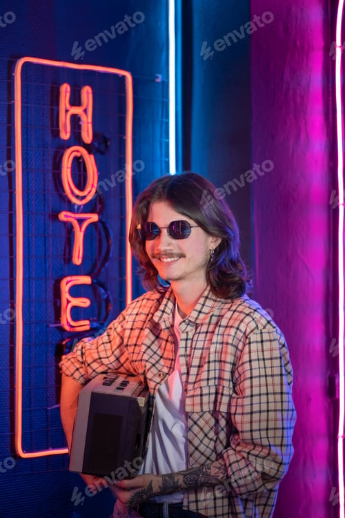 Preview: Coul yong man with old tape recorder in hand. Retro neon style nostalgia