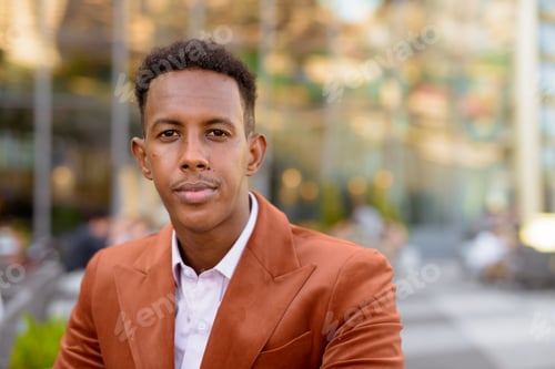 Preview: Portrait of handsome black African businessman outdoors in coffee shop