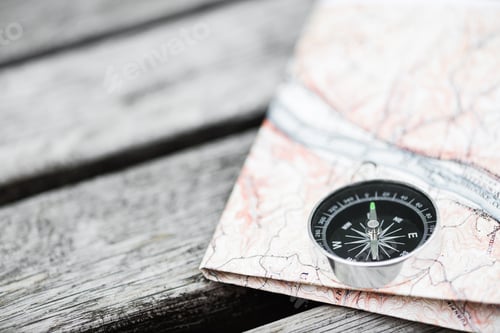Preview: Compass and map on a beautiful wooden surface. Top view
