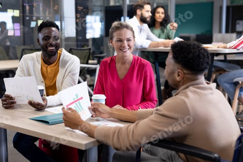Preview: Smiling biracial colleagues discussing over document together in meeting at modern workplace