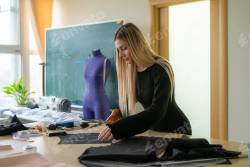 Preview: A seamstress skillfully cuts fabric on a table
