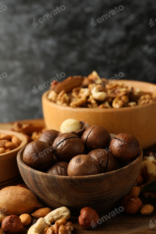 Preview: Bowl with macadamia and different nuts on wooden table