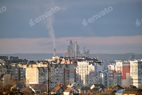 Preview: Cement plant with high factory structure and tower cranes at industrial production area near city