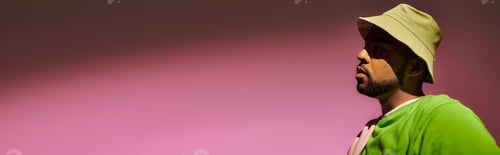 Preview: trendy young man with beard in panama posing in profile on pink background, fashion concept, banner