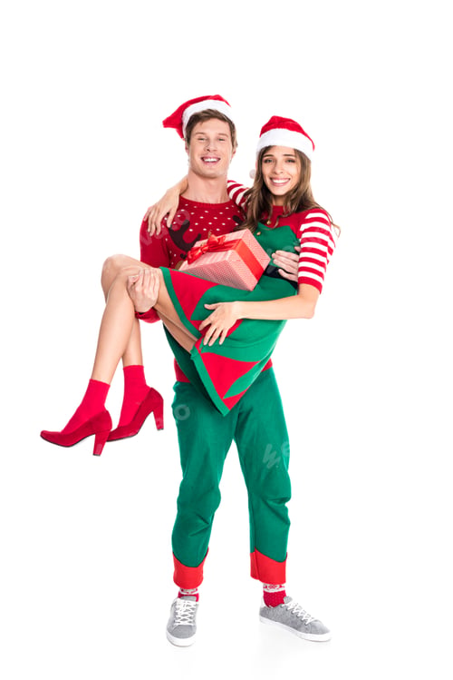 Preview: smiling man in santa hat holding girlfriend with present isolated on white