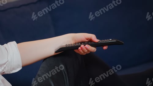 Preview: Close up of caucasian hand using remote controller for TV searching channels