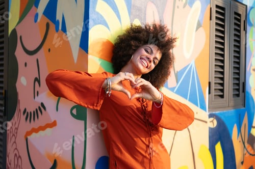 Preview: Successful woman embracing a feeling of liberation, standing confidently against vibrant street art