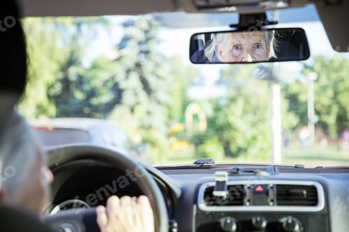 Preview: Reflection of senior woman in rear view mirror