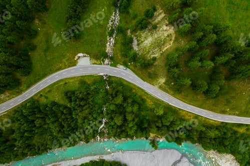 Preview: Inn River flowing in the forest in Switzerland. Aerial view from drone on a blue river in the