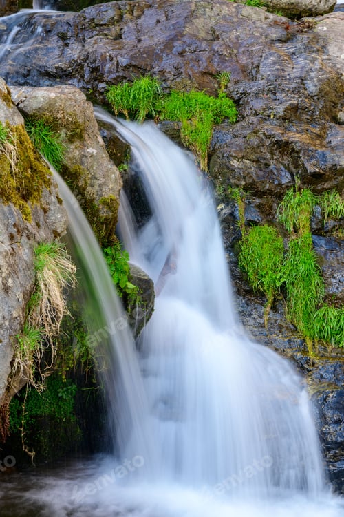 Preview: Long exposure shot of a waterfall in a forest.