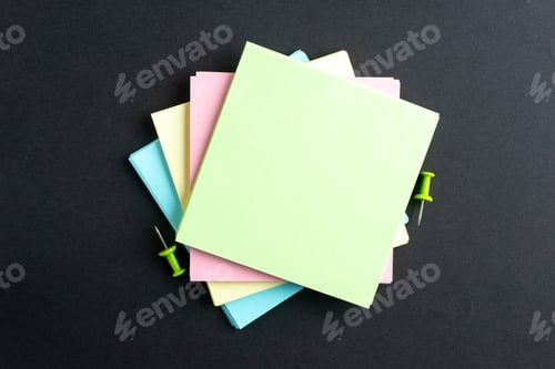 Preview: Top view of stacked sticky note cubes on isolated black background with free space