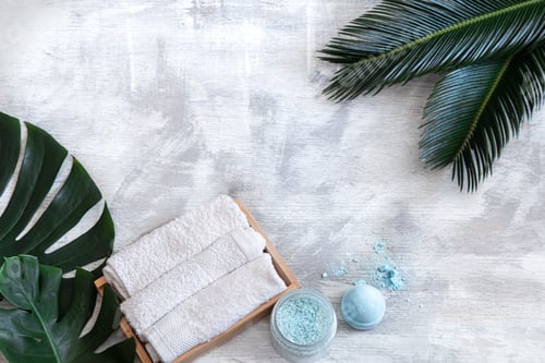 Preview: Spa. Body care items on a white background with tropical leaves. Summer accessories. Space for text.