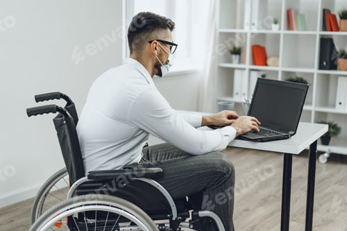 Preview: Disabled businessman doing his job and wearing medical face mask