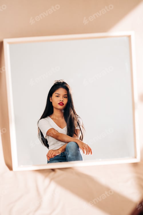 Preview: Young confident woman reflecting in mirror