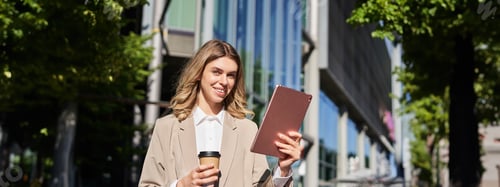 Preview: Successful businesswoman checking her work project on way to office, standing on street with
