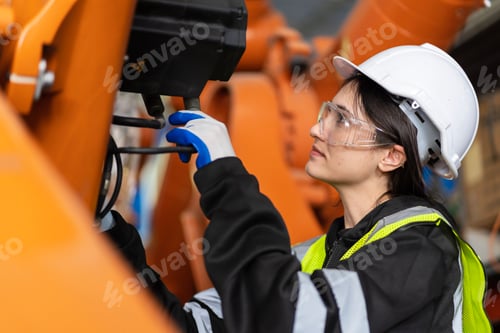 Preview: A team of female engineers meeting to inspect computer-controlled steel welding robots.