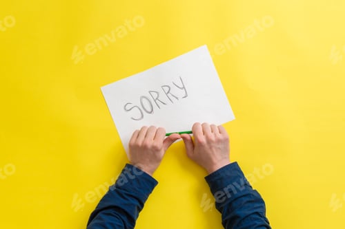 Preview: a person hands holding a paper sheet with the sorry word