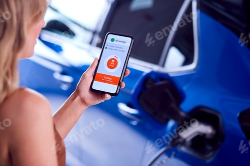 Preview: Woman Charging Electric Car With Cable Using App On Phone To Monitor Battery Level