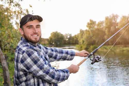 Preview: Man with rod fishing at riverside. Recreational activity