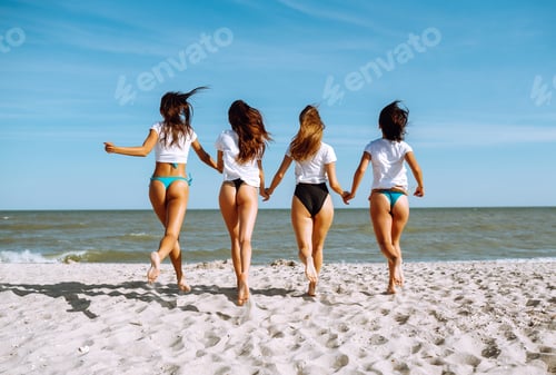 Preview: Four girls having fun on beach. Group of girlfriends enjoying on beach holiday. Summer lifestyle.