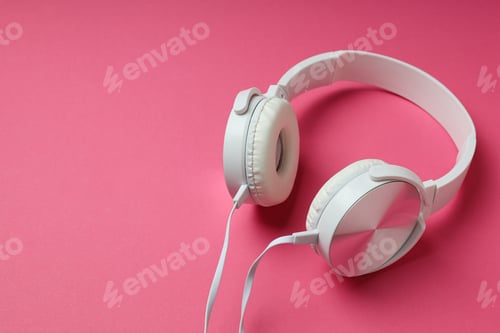 Preview: White, on-ear headphones with a wire on a pink background.