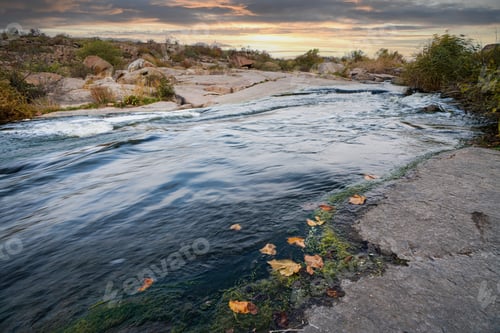 Preview: A small shining stream flows among smooth wet and dark stones