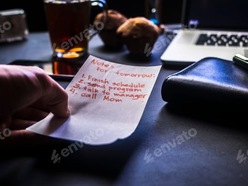 Preview: close up hand holding notepad sheet over the black office table
