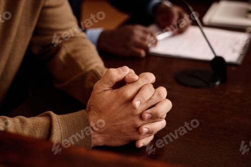 Preview: Focus on clasped hands of young male suspect waiting for announcing verdict
