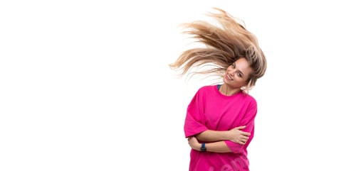 Preview: portrait of a cheerful young woman in a fuchsia t-shirt with hair flying in the wind on a white